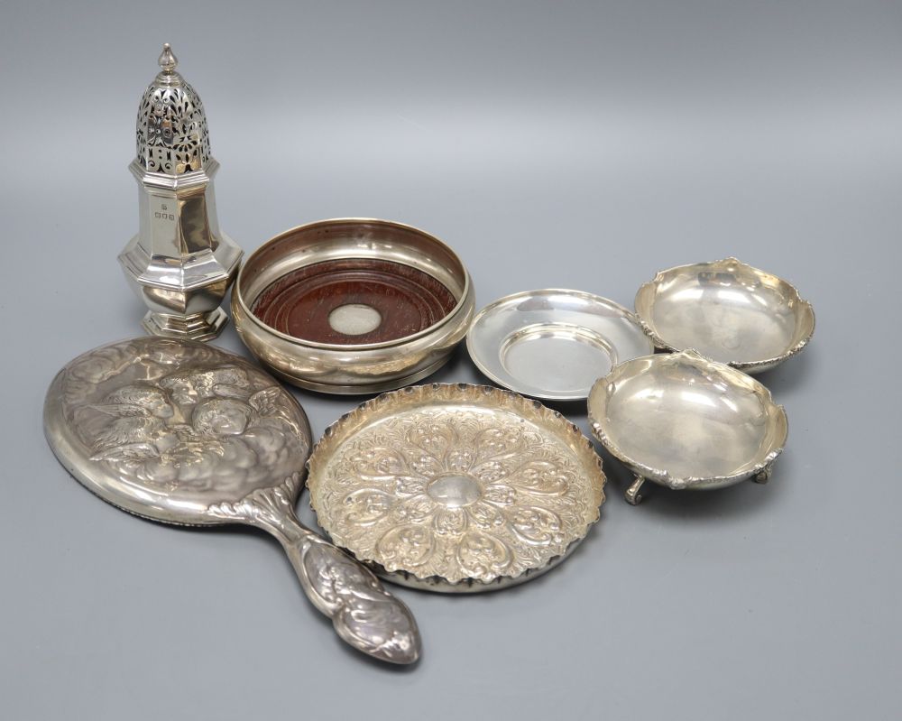 A pair of Indian white metal bon-bon dishes, a modern wine coaster, a Victorian embossed circular silver tray, a nut dish, a Reynolds A